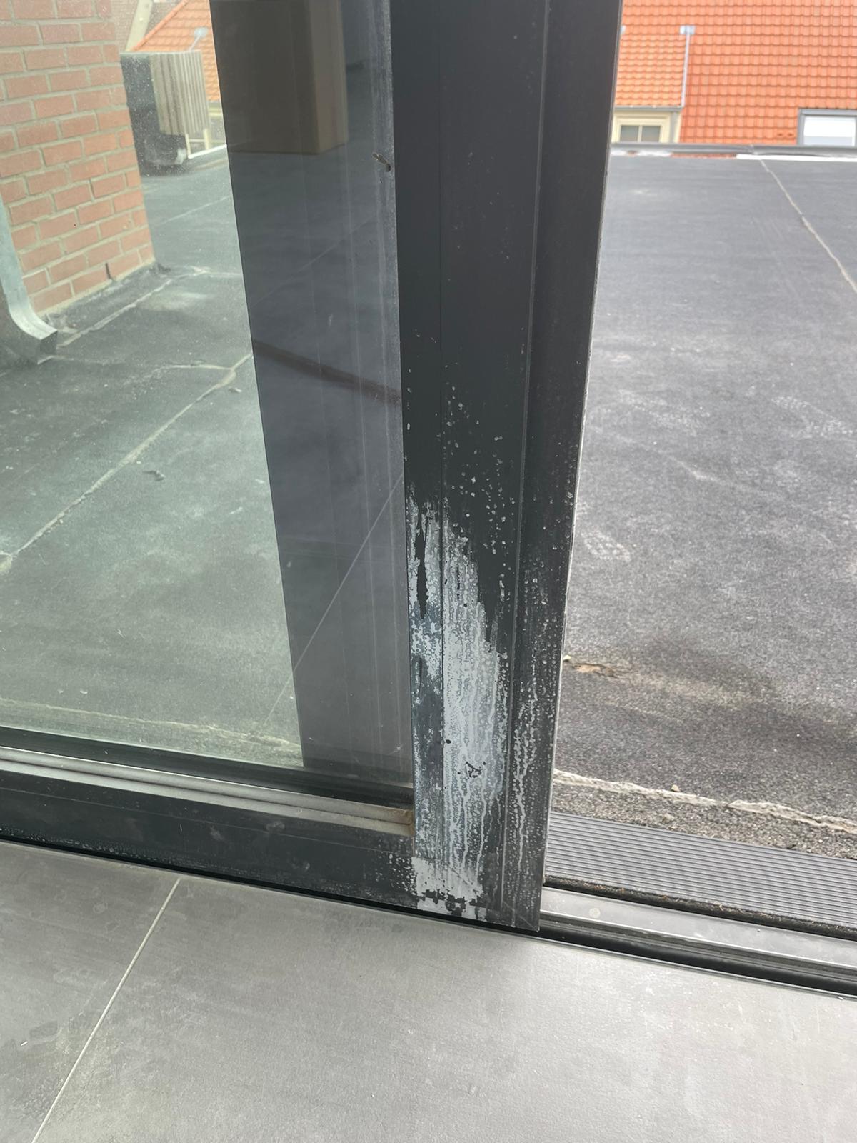 Kalk op zwarte raamprofielen